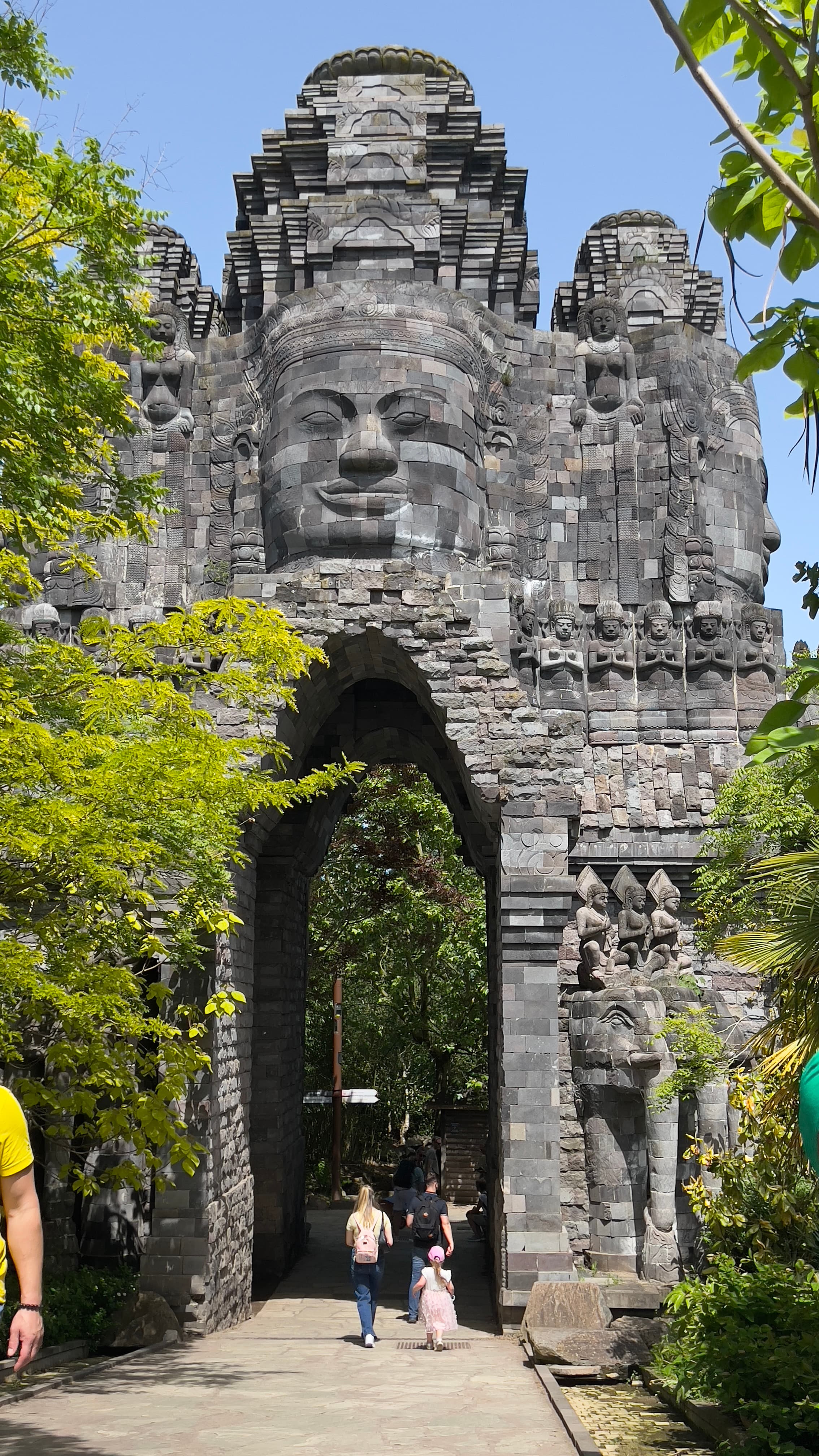 Stone temple gate with carved faces at Pairi Daiza Belgium.
